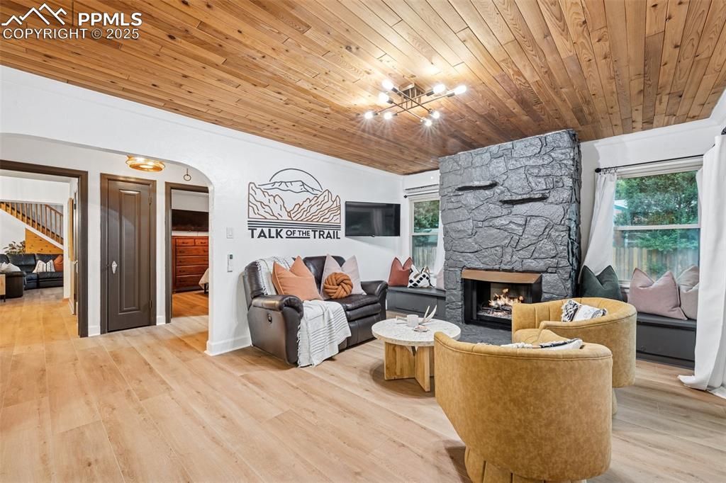 Image 12 of 48: Living area with wood ceiling, a fireplace, healthy amount of natural light