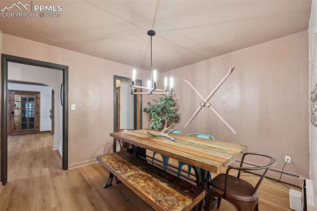 Image 17 of 48: Dining area featuring light wood finished floors, a baseboard radiator, and