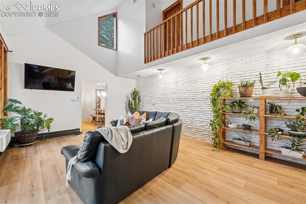Image 20 of 48: Living area with a high ceiling and wood finished floors