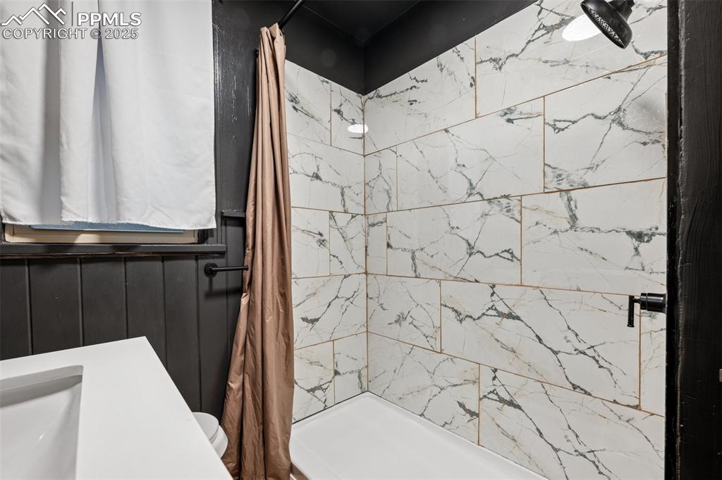 Image 21 of 48: Full bath featuring a tile shower and toilet