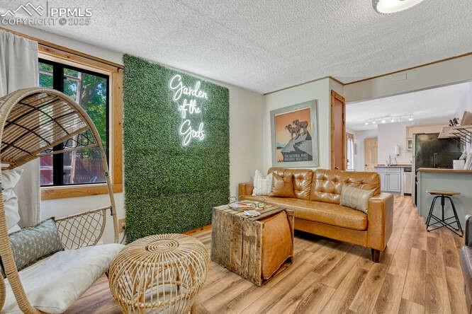 Image 33 of 48: STR portion: Living area featuring light wood-type flooring and a textured