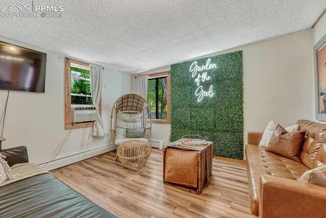 Image 34 of 48: STR portion: Living area featuring light wood finished floors, a textured c