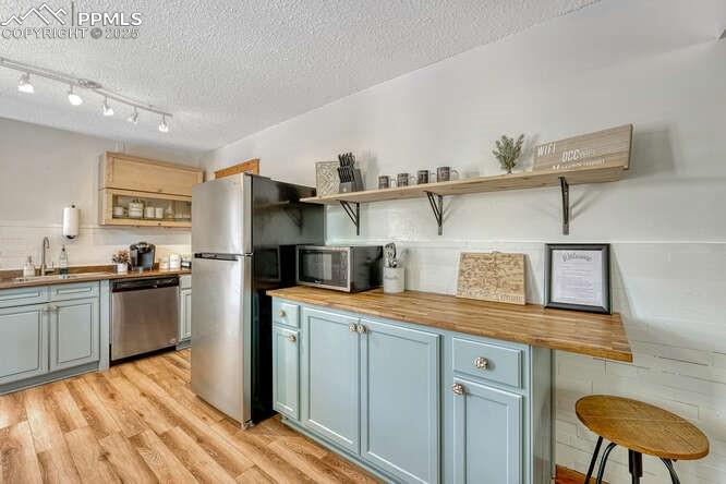 Image 37 of 48: STR portion: Kitchen featuring butcher block countertops, open shelves, a t
