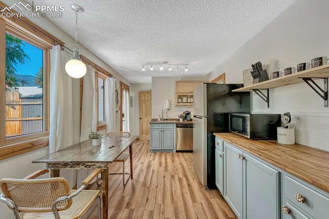 Image 38 of 48: STR portion: Kitchen featuring wood counters, light wood finished floors, a
