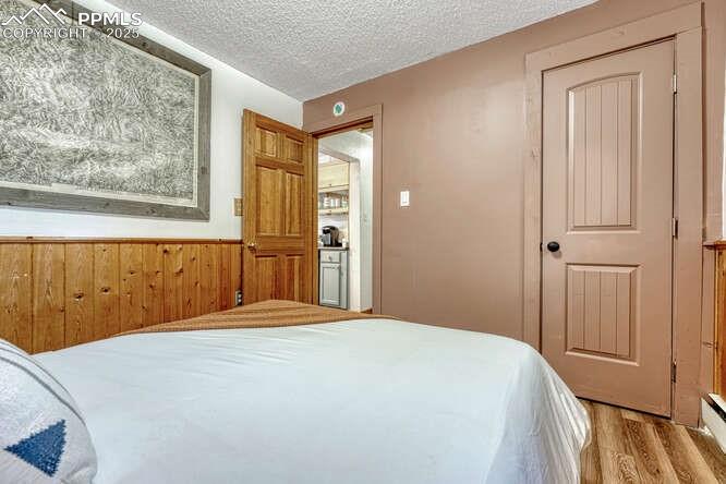 Image 43 of 48: STR portion: Bedroom featuring light wood-type flooring, a textured ceiling