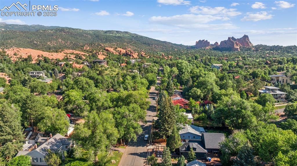 Image 7 of 48: Drone / aerial view of a mountain backdrop and a heavily wooded area. Gard