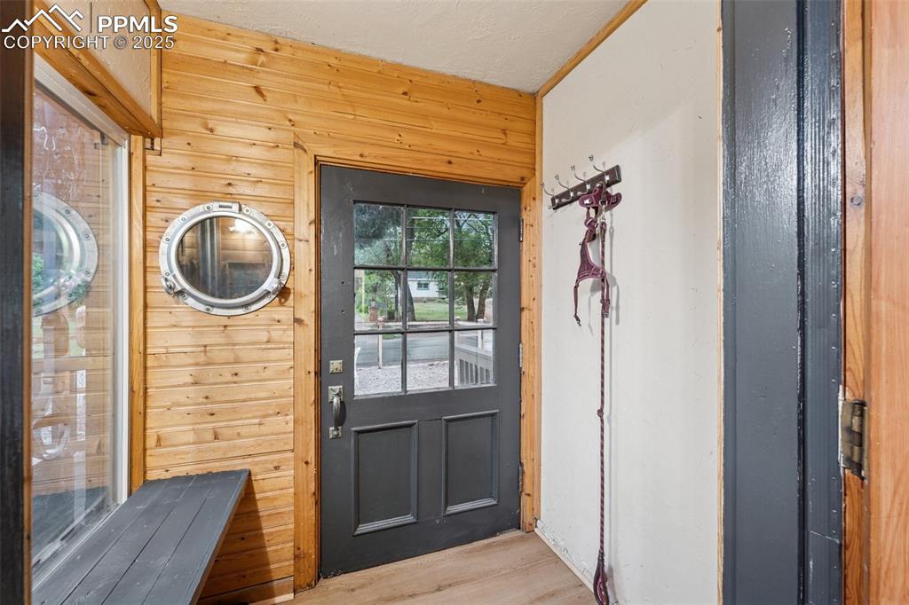 Image 9 of 48: Entryway with wood finished floors and wooden walls