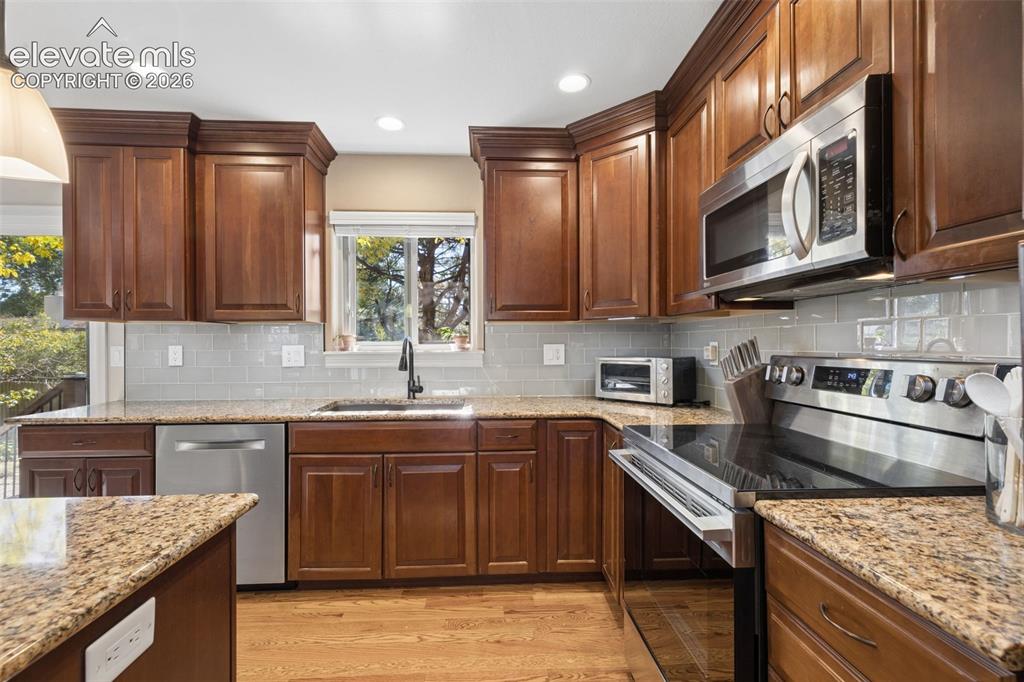 Image 10 of 36: Updated kitchen with island, stainless steel appliances, granite counters a