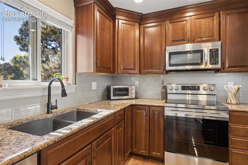 Image 11 of 36: Updated kitchen with island, stainless steel appliances, granite counters a