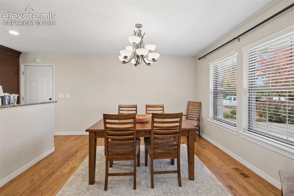Image 14 of 36: Separate dining area with wood floors and large windows