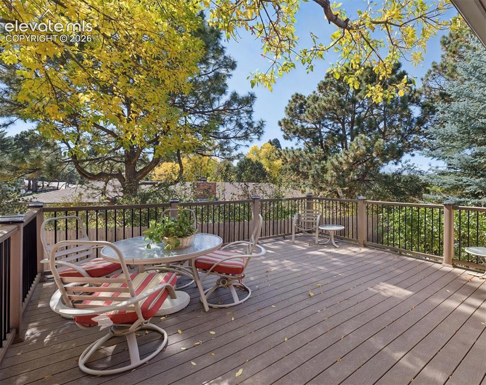 Image 15 of 36: Trex deck directly off the great room and kitchen surrounded by mature tree
