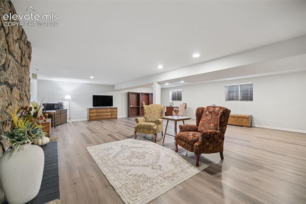 Image 23 of 36: Basement is open concept and features LVP flooring and gas fireplace with s