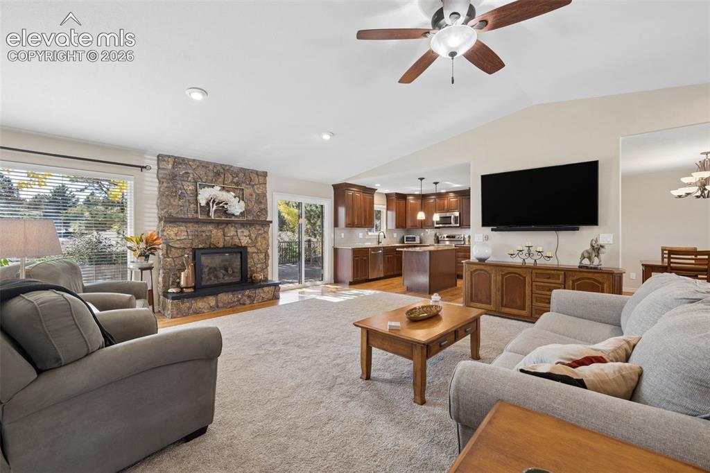 Image 5 of 36: Open-concept great room featuring vaulted ceilings and gas fireplace with s