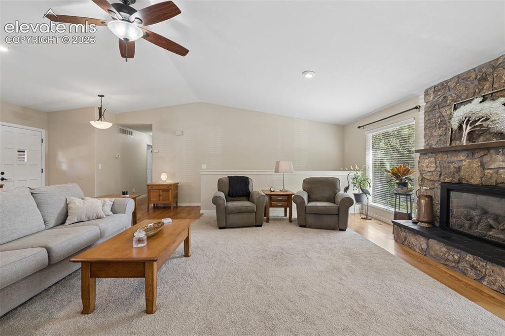 Image 7 of 36: Vaulted ceilings, floor-to-ceiling natural stone fireplace with a black hea