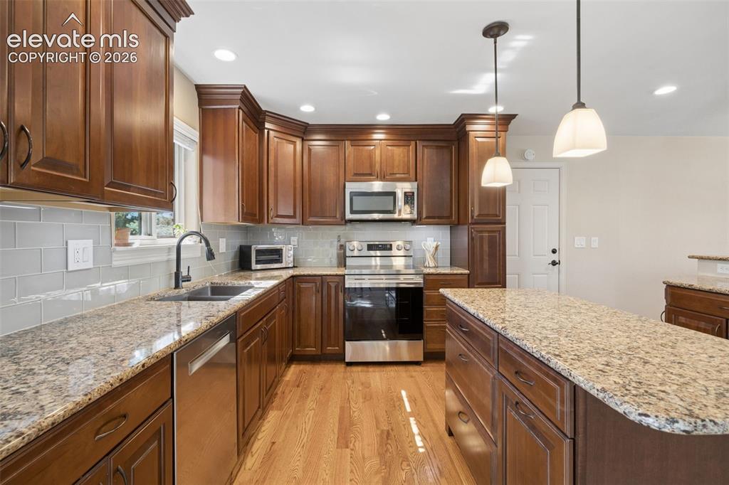 Image 8 of 36: Updated kitchen featuring granite countertops and glass subway tile backspl