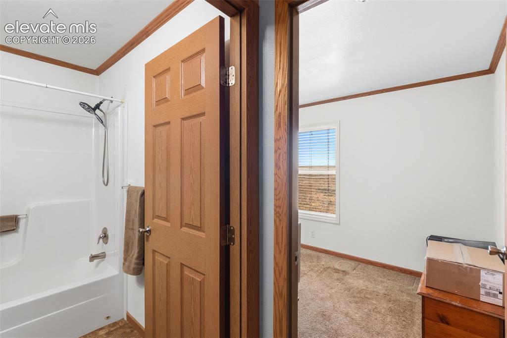 Image 9 of 19: Hall way to full bath and north bedroom.