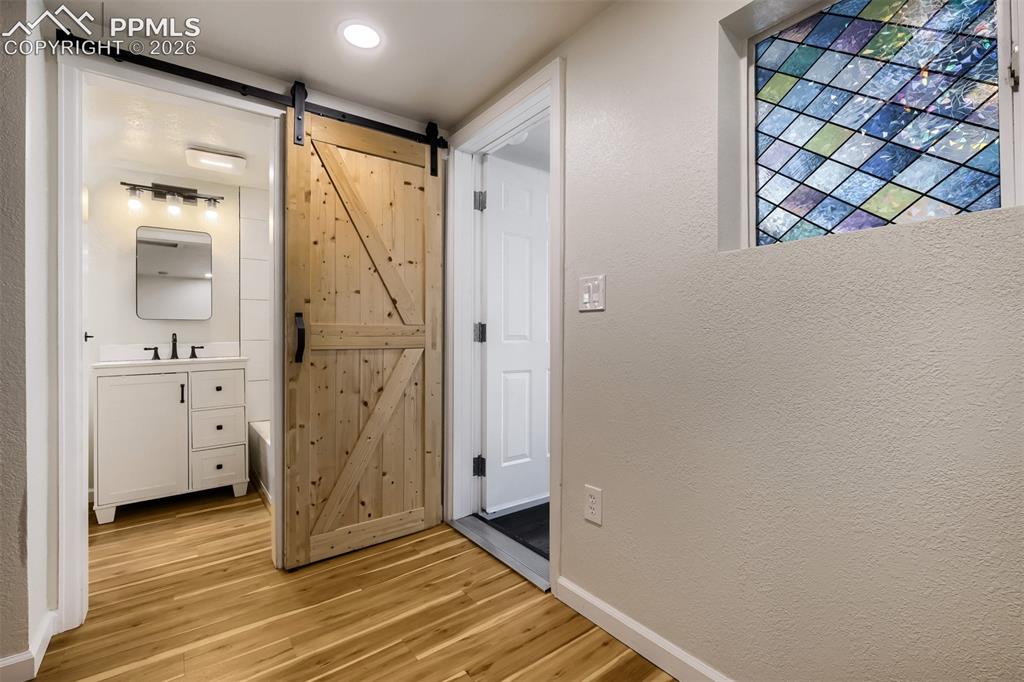 Image 11 of 32: Main living area featuring wood-finish flooring, light grey wall paint, and