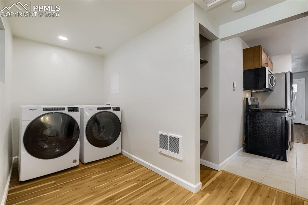 Image 14 of 32: Kitchen featuring wood cabinetry, stainless steel appliances, a black doubl
