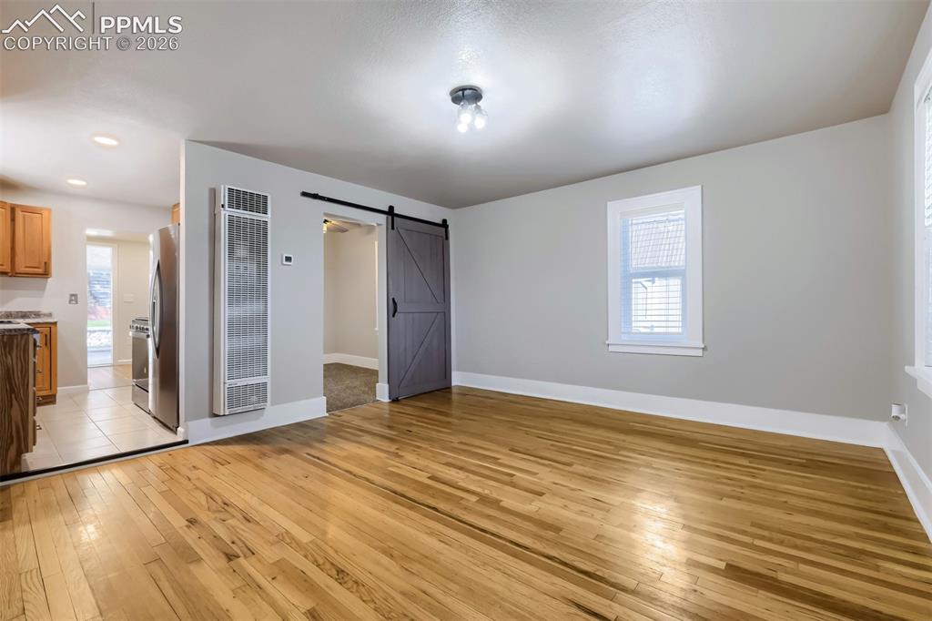 Image 6 of 32: Virtually Staged Living area featuring wood-finish flooring, light gray wal