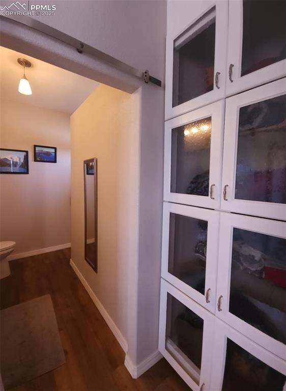 Image 17 of 47: Hallway with baseboards and dark wood finished floors