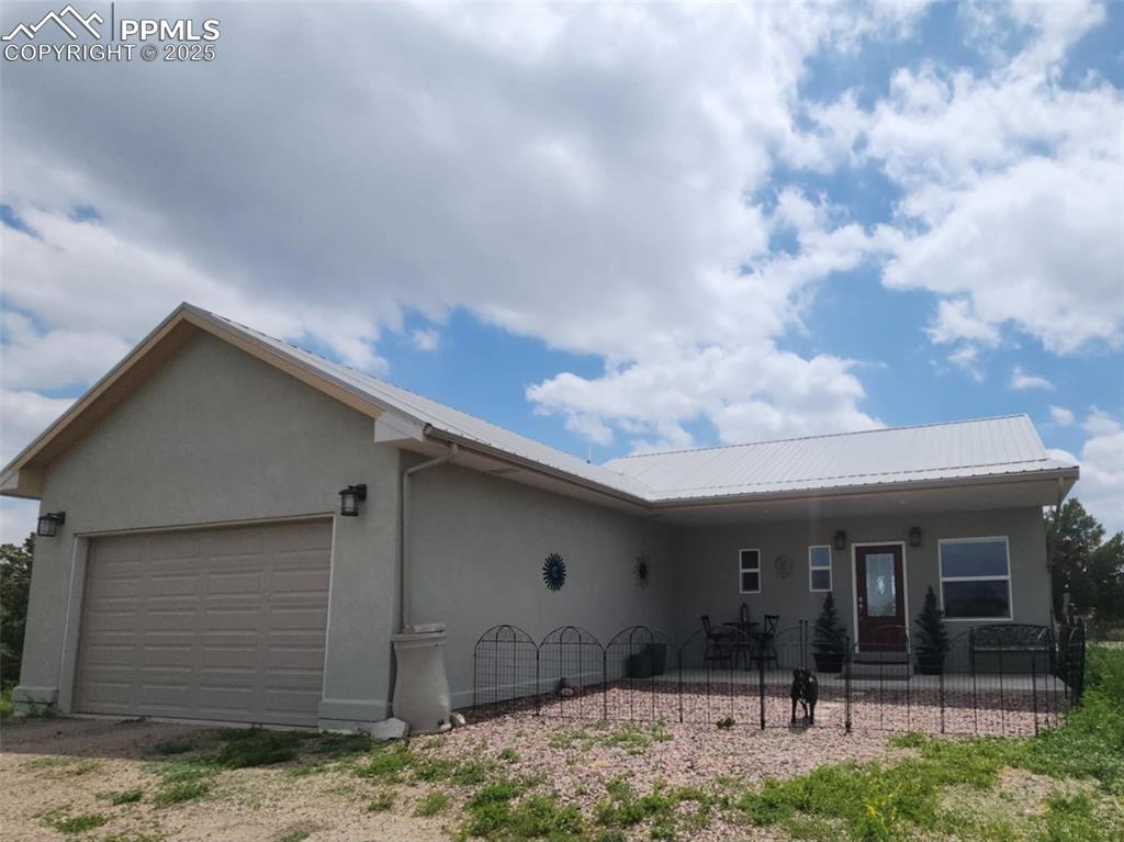 Image 2 of 47: Single story home featuring stucco siding, an attached garage, a porch, and