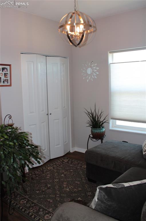 Image 23 of 47: Sitting room featuring dark wood-style floors and a chandelier