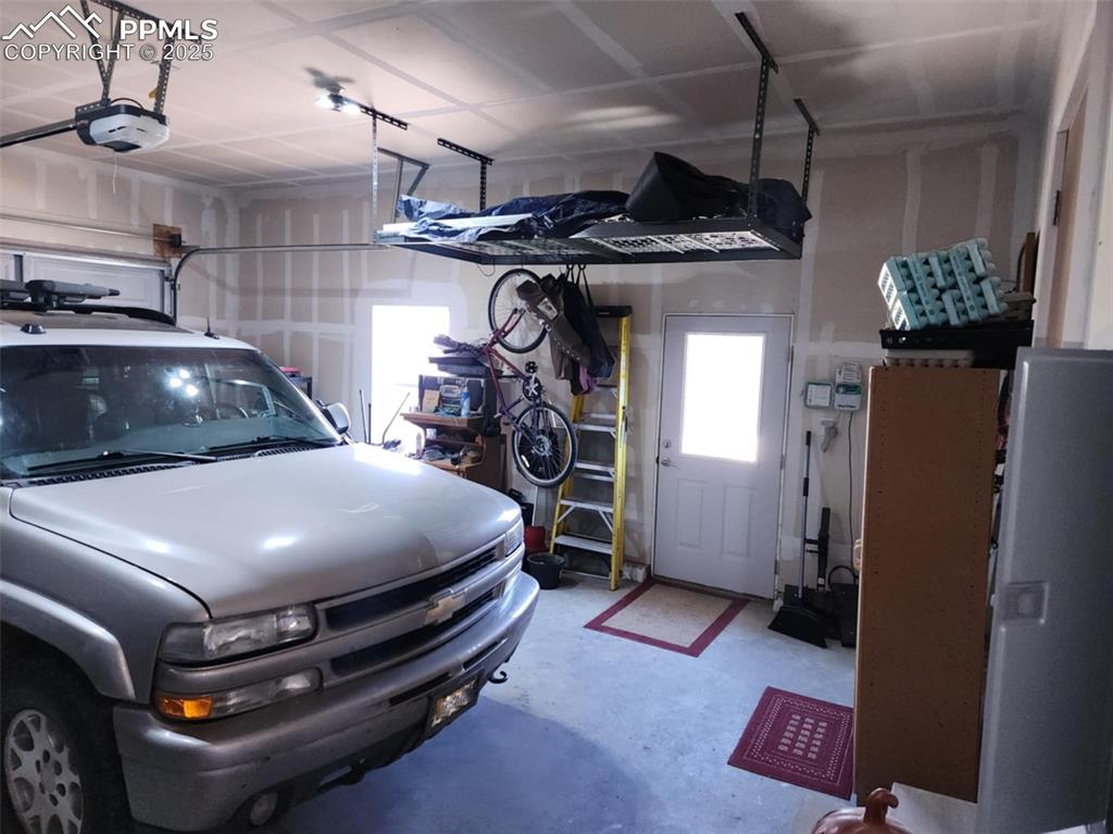 Image 27 of 47: Garage featuring a garage door opener