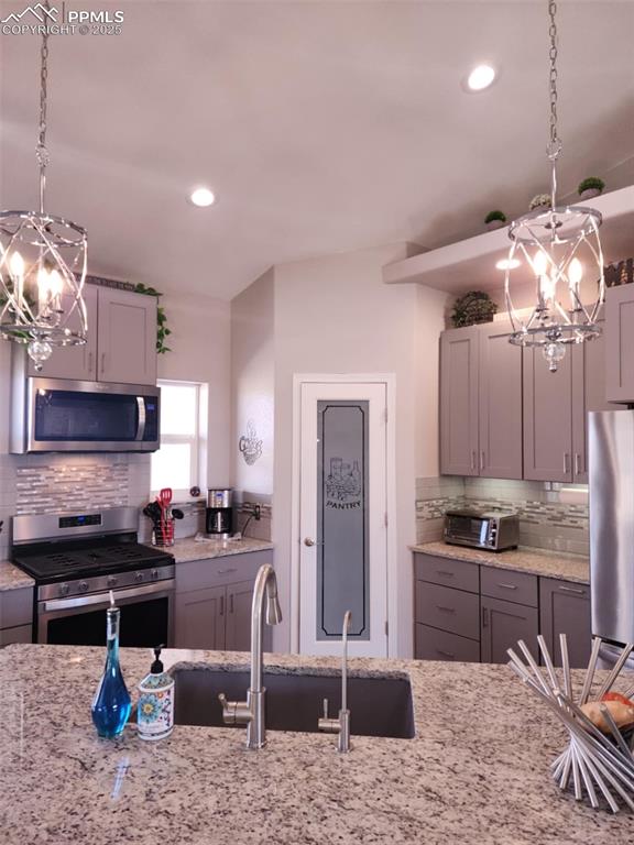 Image 7 of 47: Kitchen with hanging light fixtures, a chandelier, backsplash, and recessed