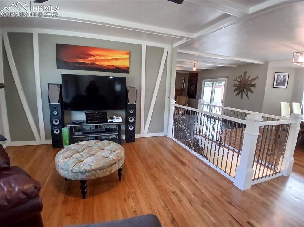 Image 7 of 49: Living room featuring hardwood flooring and beam ceiling