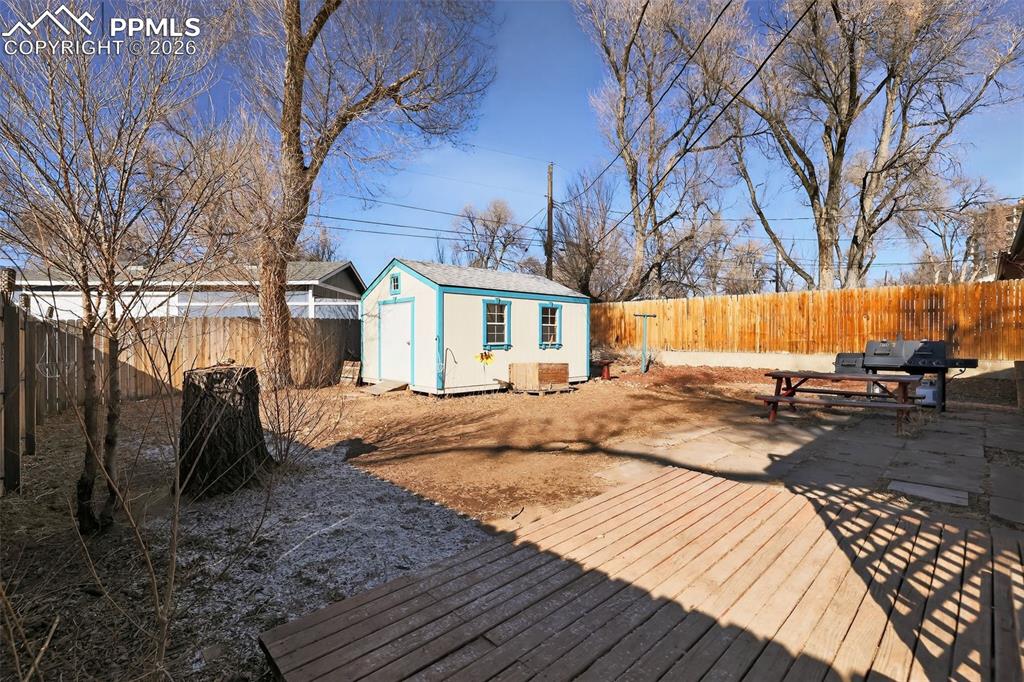 Image 8 of 15: Deck featuring a fenced backyard, a storage shed, and a grill