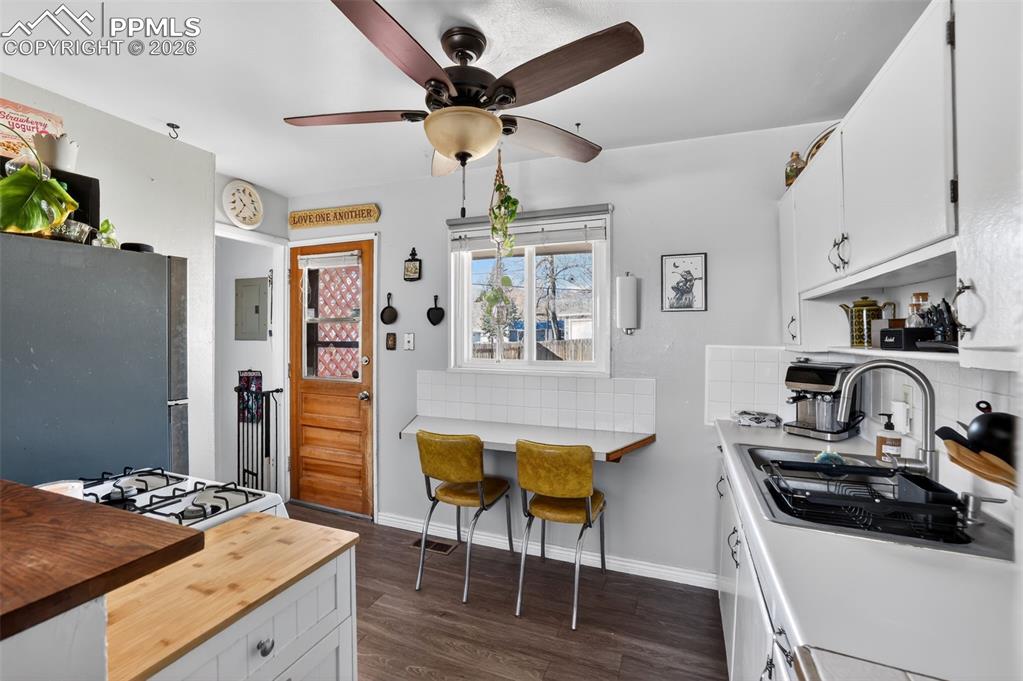 Image 9 of 15: Kitchen featuring white cabinetry, butcher block countertops, freestanding