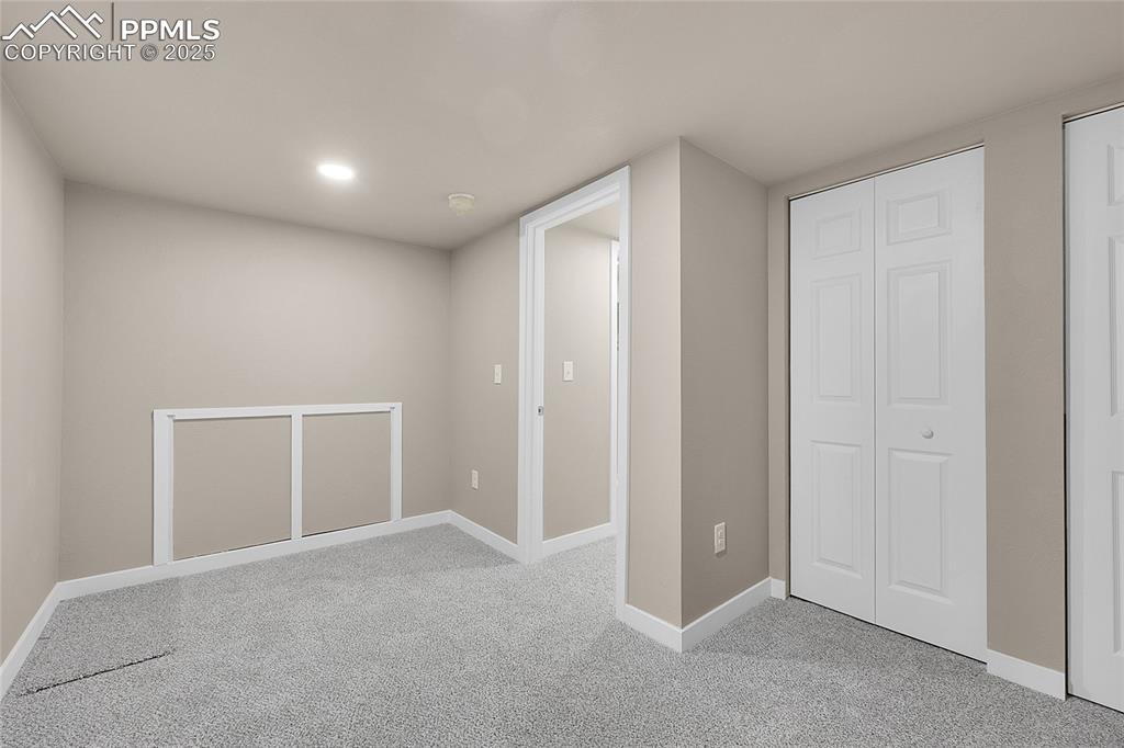 Image 12 of 15: Basement with baseboards and light colored carpet
