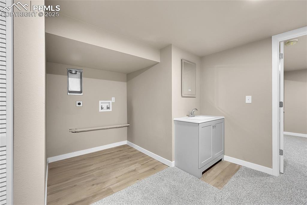 Image 13 of 15: Washroom with washer hookup, light wood-style floors, and electric dryer ho