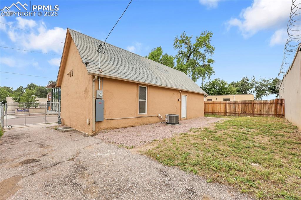 Image 14 of 15: View of side of home featuring a fenced backyard, roof with shingles, and s