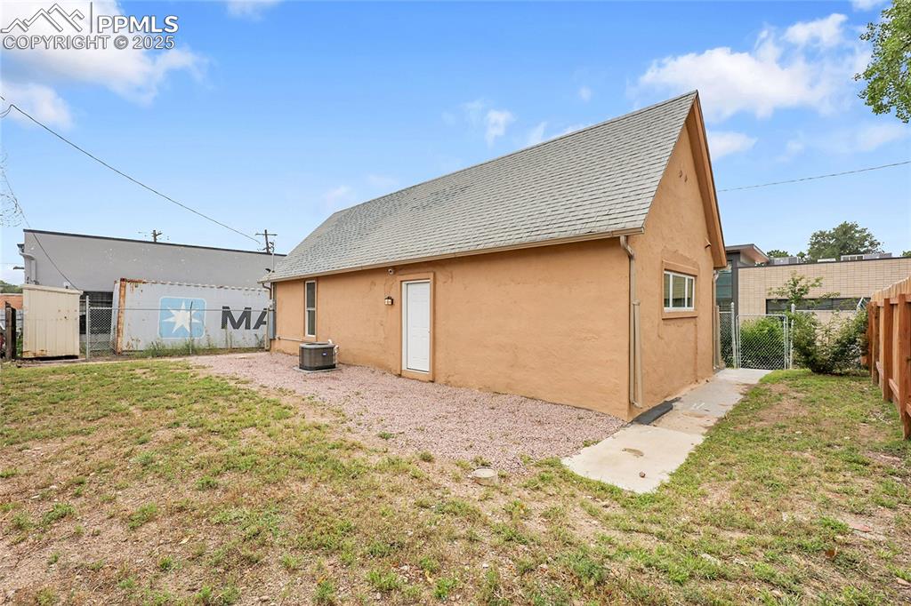 Image 15 of 15: Rear view of house featuring a gate, stucco siding, and roof with shingles