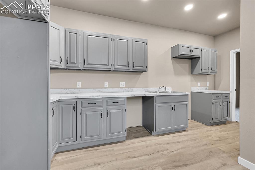 Image 4 of 15: Kitchen featuring gray cabinets, light countertops, light wood-type floorin