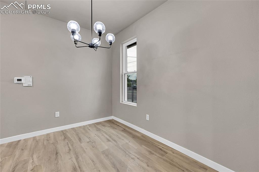 Image 5 of 15: Unfurnished dining area with light wood-style floors and a chandelier