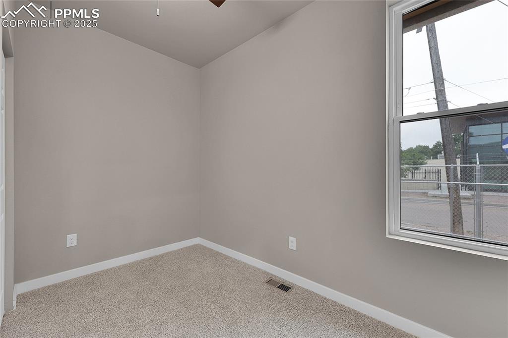 Image 7 of 15: Unfurnished room with carpet, ceiling fan, and lofted ceiling