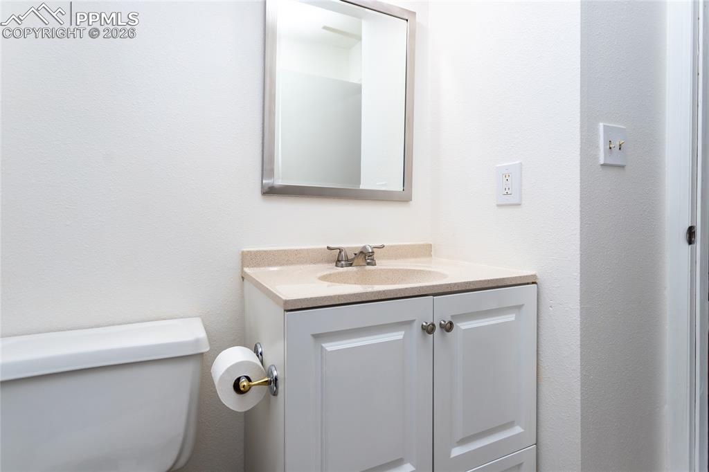 Image 11 of 30: Half bath with vanity and toilet