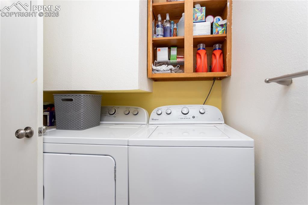 Image 12 of 30: Laundry room with washer and clothes dryer and a textured wall