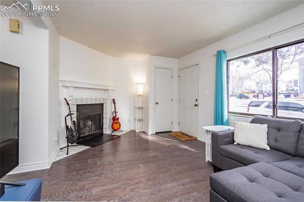 Image 7 of 30: Living room featuring wood finished floors and a tiled fireplace