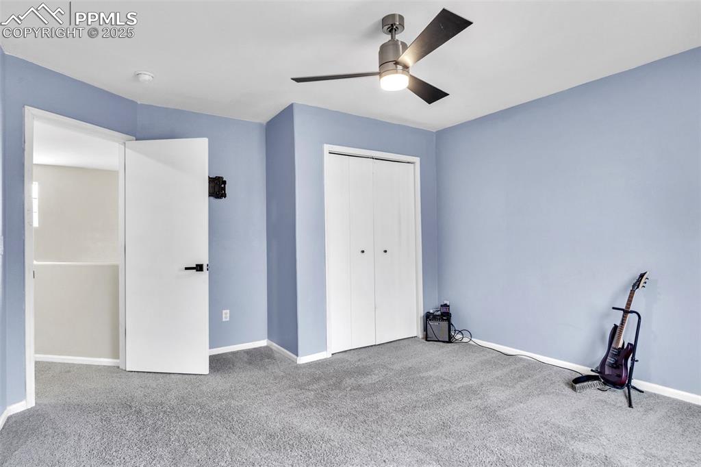Image 13 of 26: Unfurnished bedroom with carpet, a closet, and a ceiling fan
