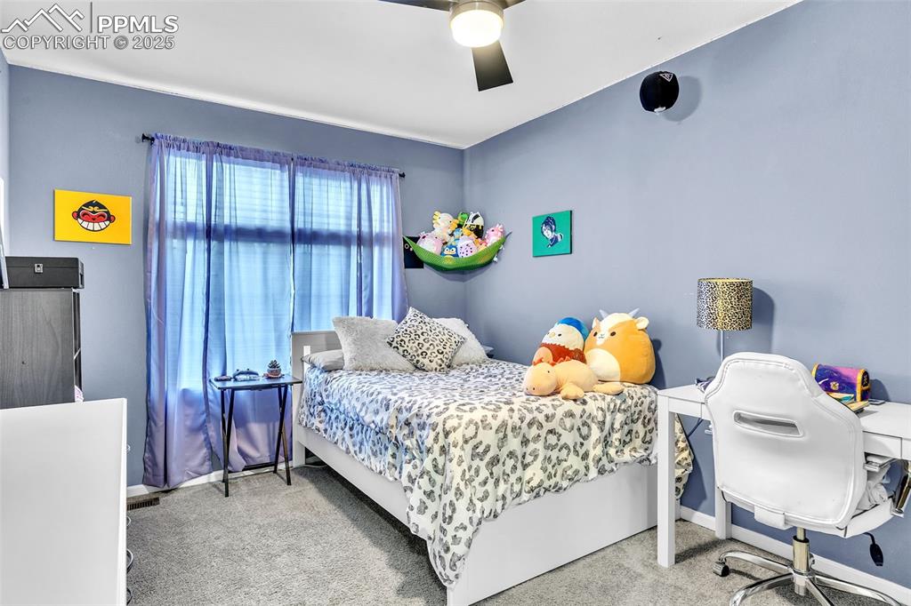Image 14 of 26: Bedroom with light colored carpet and ceiling fan