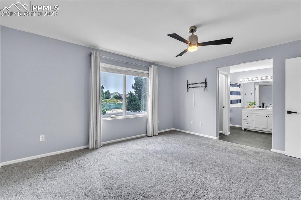 Image 18 of 26: Unfurnished bedroom featuring carpet flooring, a ceiling fan, and ensuite b