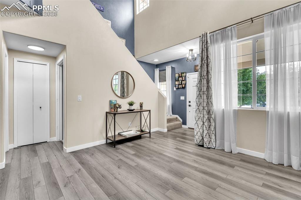 Image 2 of 26: Foyer featuring light wood-type flooring, stairs, and a towering ceiling