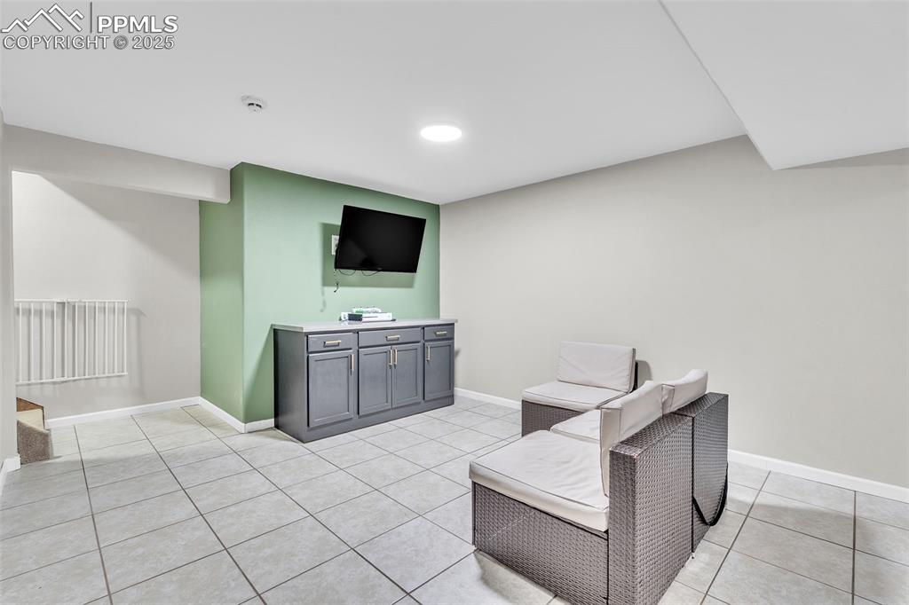 Image 22 of 26: Sitting room with light tile patterned floors and baseboards