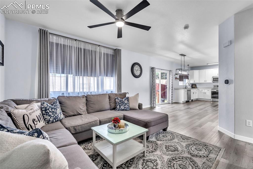 Image 5 of 26: Living room with light LVP finished floors and ceiling fan