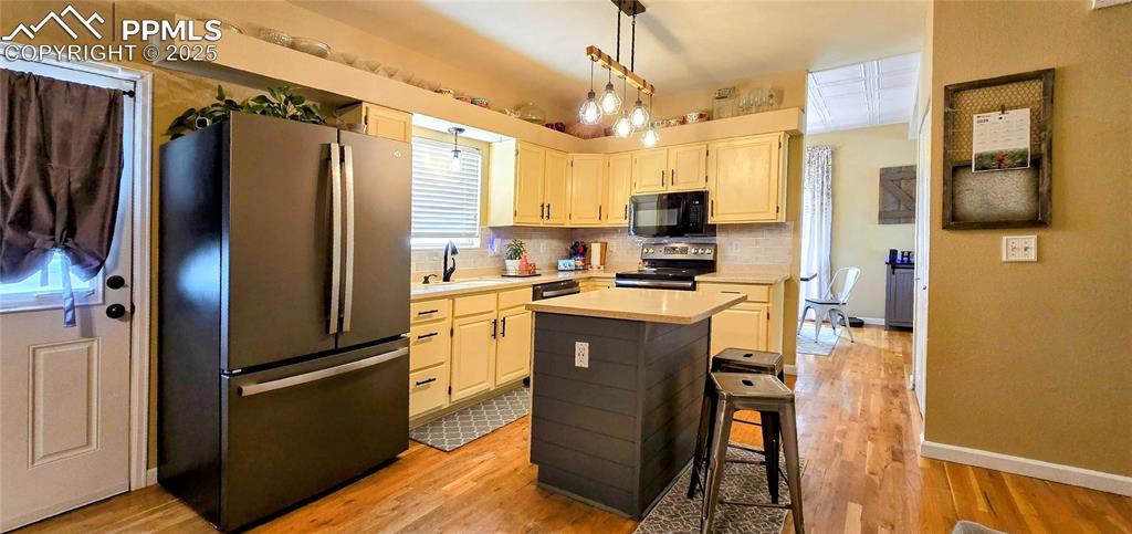 Image 12 of 48: Kitchen with stainless steel appliances, light countertops, light wood-styl