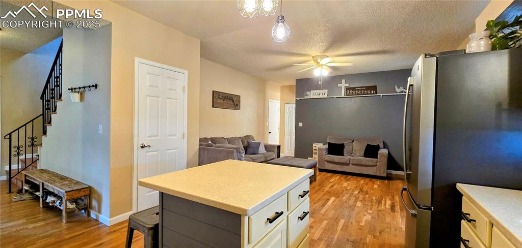 Image 17 of 48: Kitchen with freestanding refrigerator, light wood finished floors, a textu