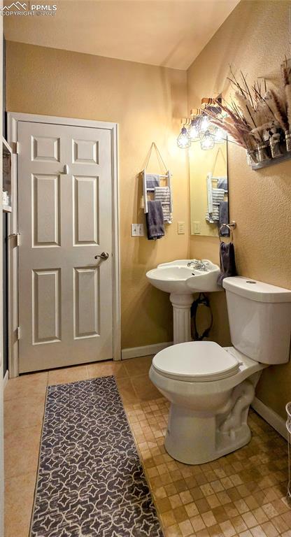 Image 24 of 48: Bathroom featuring a textured wall and light tile patterned flooring